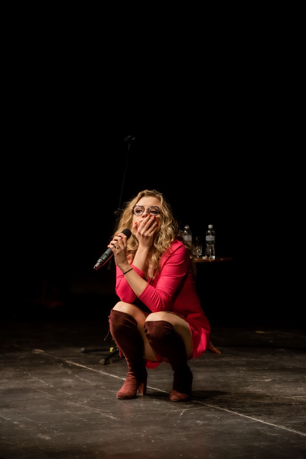 Aleksandra kuca na scenie z mikrofonem